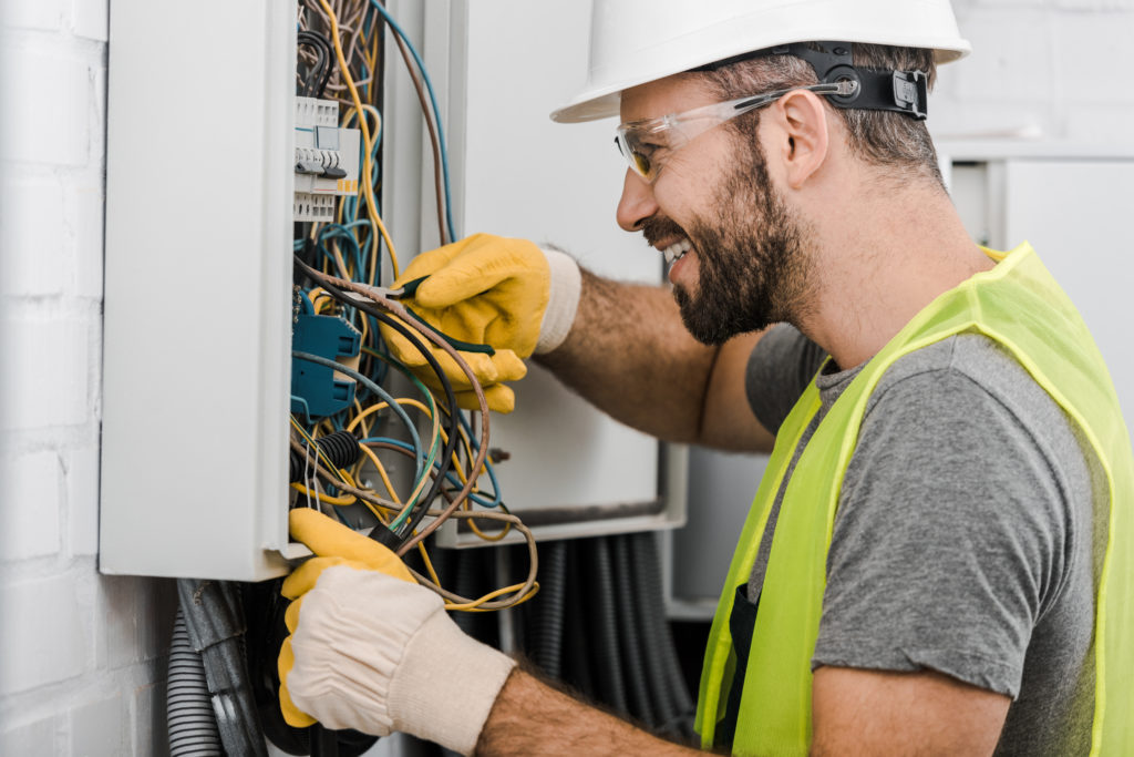 Dm- service-Side,View,Of,Smiling,Handsome,Electrician,Repairing,Electrical,Box,With